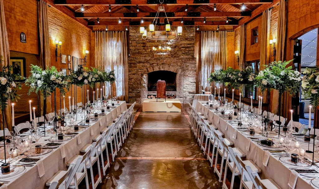 A large room with tables and chairs set up for a wedding reception.